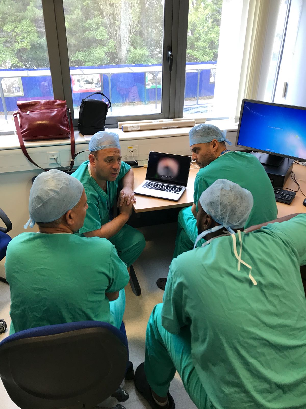 Mr Oliver Wiseman discussing surgical technique with visiting surgeons in Cambridge